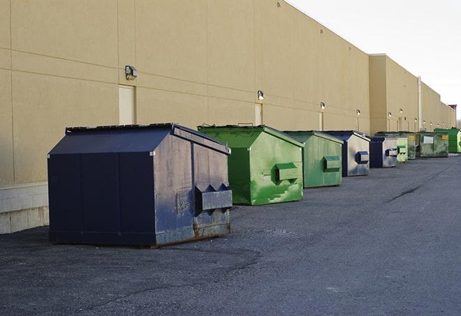 tilted front-load dumpsters being emptied by waste management workers in Coventry